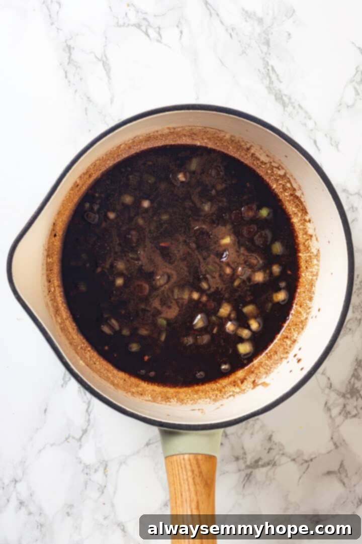 This spicy ramen recipe is an easy budget-friendly dinner that's packed with flavour! Sweet, spicy and umami—and it takes minutes to make! Overhead view of spicy sauce in pan