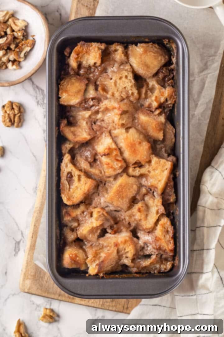 Overhead view of the golden-brown baked banana bread pudding resting in a loaf pan, perfectly set.