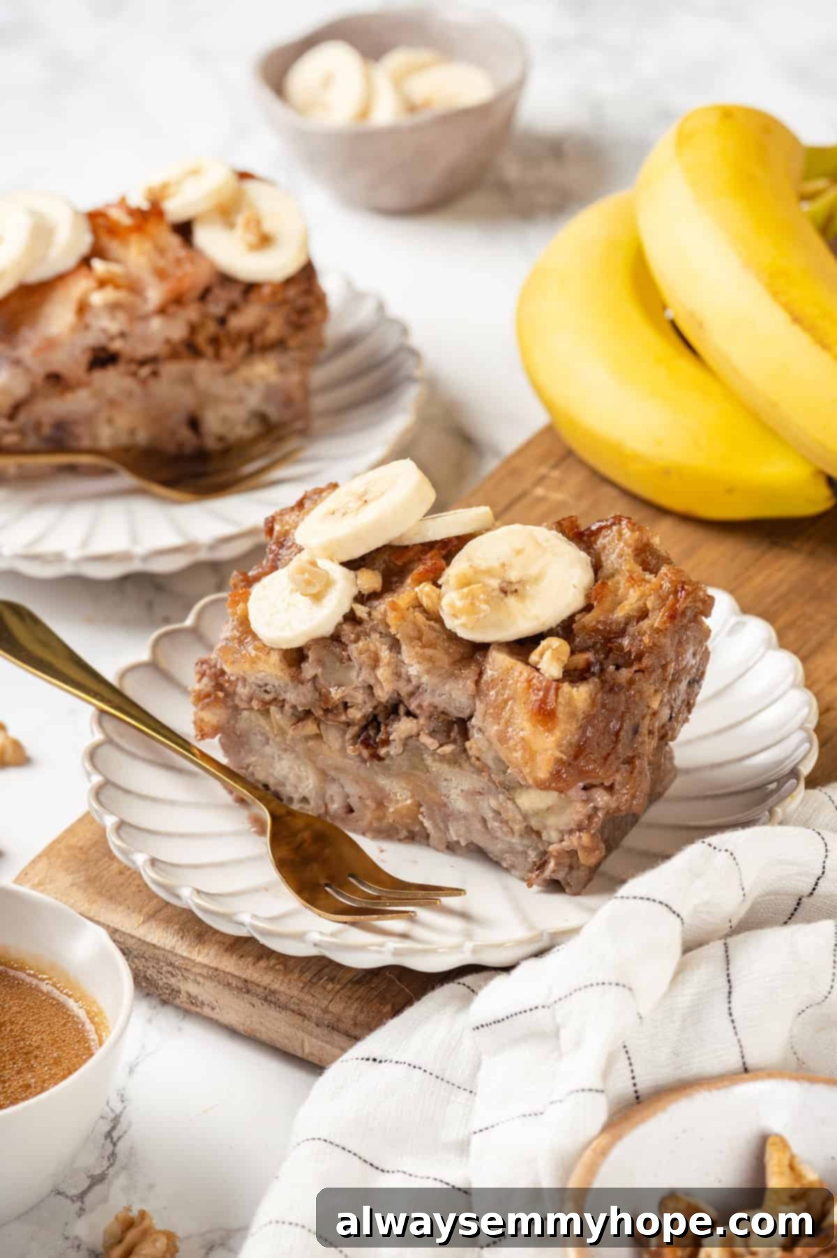 Two rustic plates of vegan banana bread pudding, garnished with fresh banana slices, set against a blurred background of whole bananas, emphasizing its natural goodness.