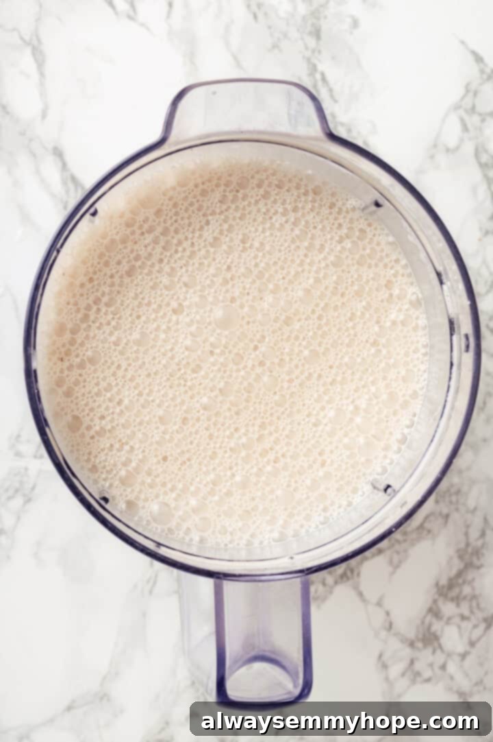Overhead view of a creamy custard mixture for banana bread pudding in a blender, perfectly smooth and ready.