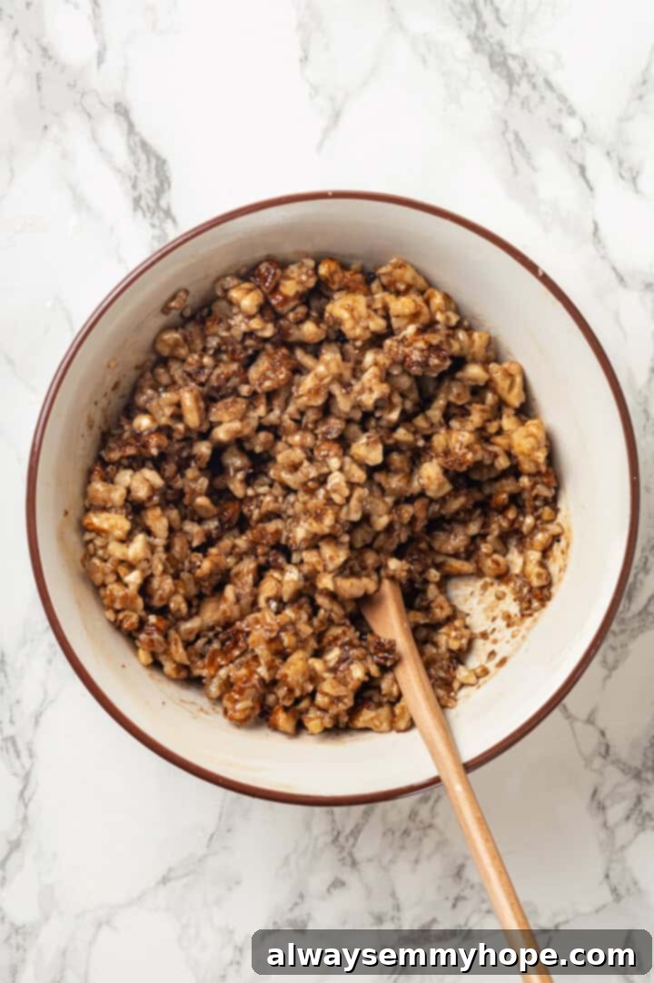 Overhead view of a bowl containing the rich walnut filling mixture for banana bread pudding, ready for layering.