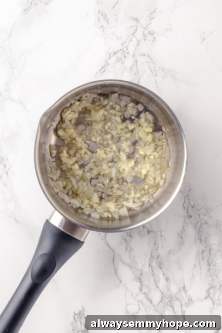 This creamy vegan pasta carbonara is a delicious plant-based alternative to the traditional recipe with mushrooms standing in for the meat! Overhead view of cooked onions in pan