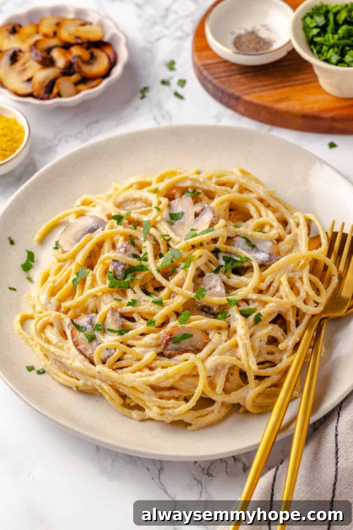 This creamy vegan pasta carbonara is a delicious plant-based alternative to the traditional recipe with mushrooms standing in for the meat! Vegan pasta carbonara on plate with fork and spoon