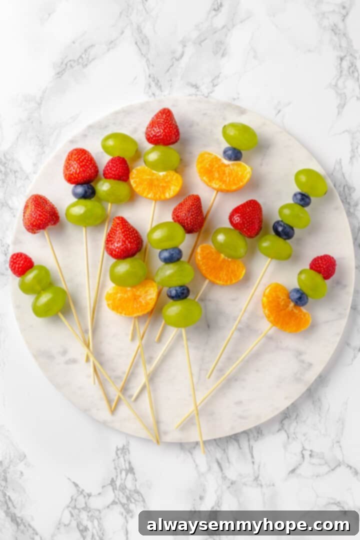 Tanghulu is one part fruit, one part candy and entirely delicious! Fruit skewers dipped in candy coating to create a sweet, crunchy shell. Overhead view of fruit skewers on marble slab