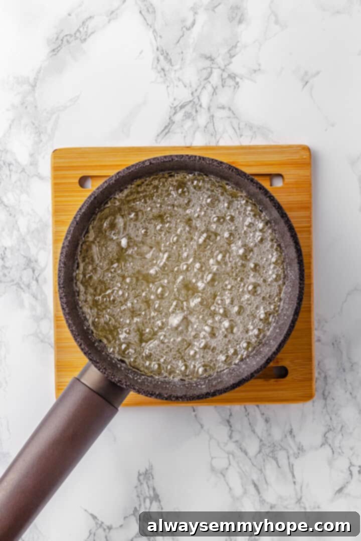 Tanghulu is one part fruit, one part candy and entirely delicious! Fruit skewers dipped in candy coating to create a sweet, crunchy shell. Sugar mixture for tanghulu boiling in pan