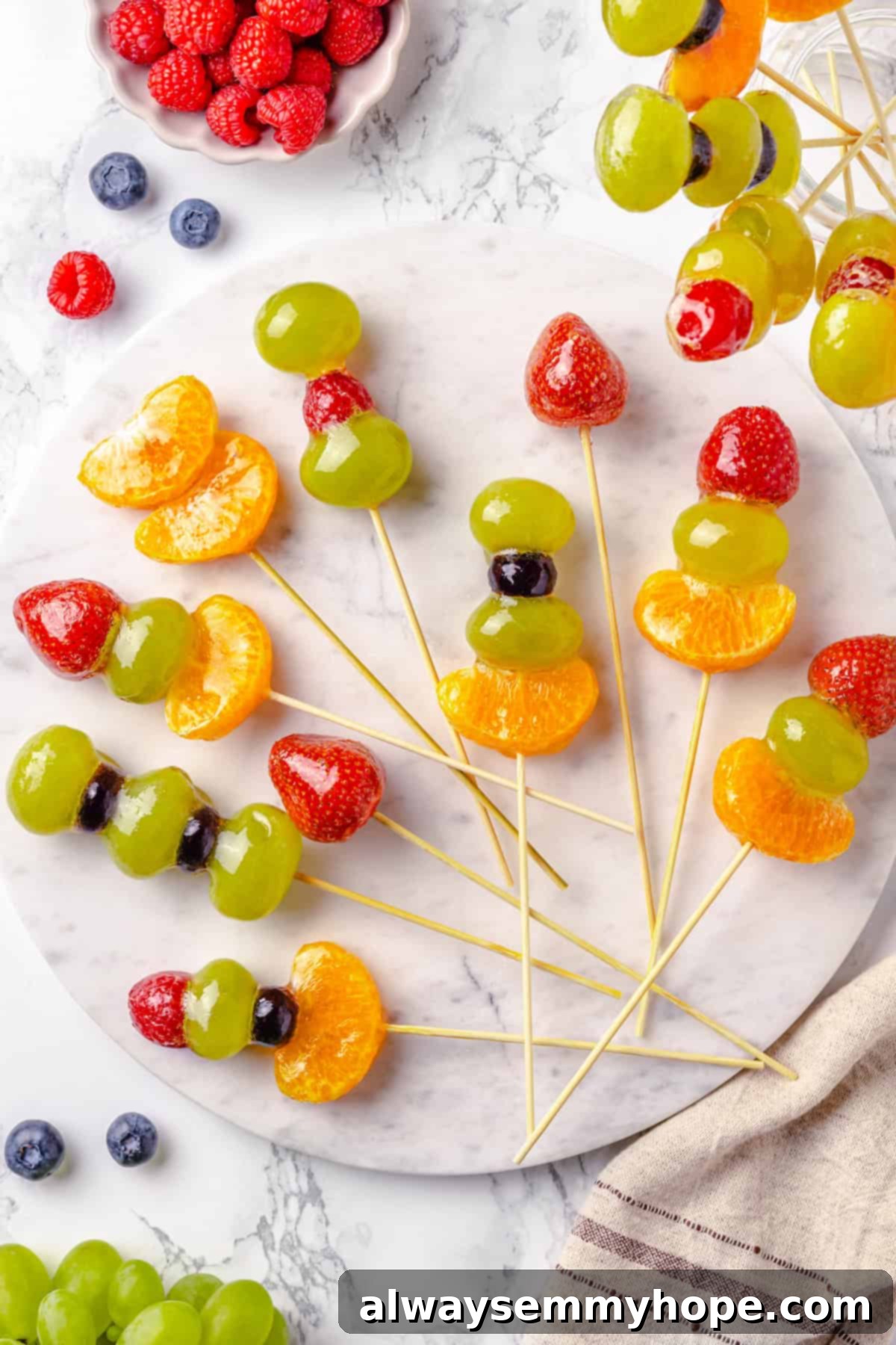 Tanghulu is one part fruit, one part candy and entirely delicious! Fruit skewers dipped in candy coating to create a sweet, crunchy shell. Overhead view of tanghulu on marble slab