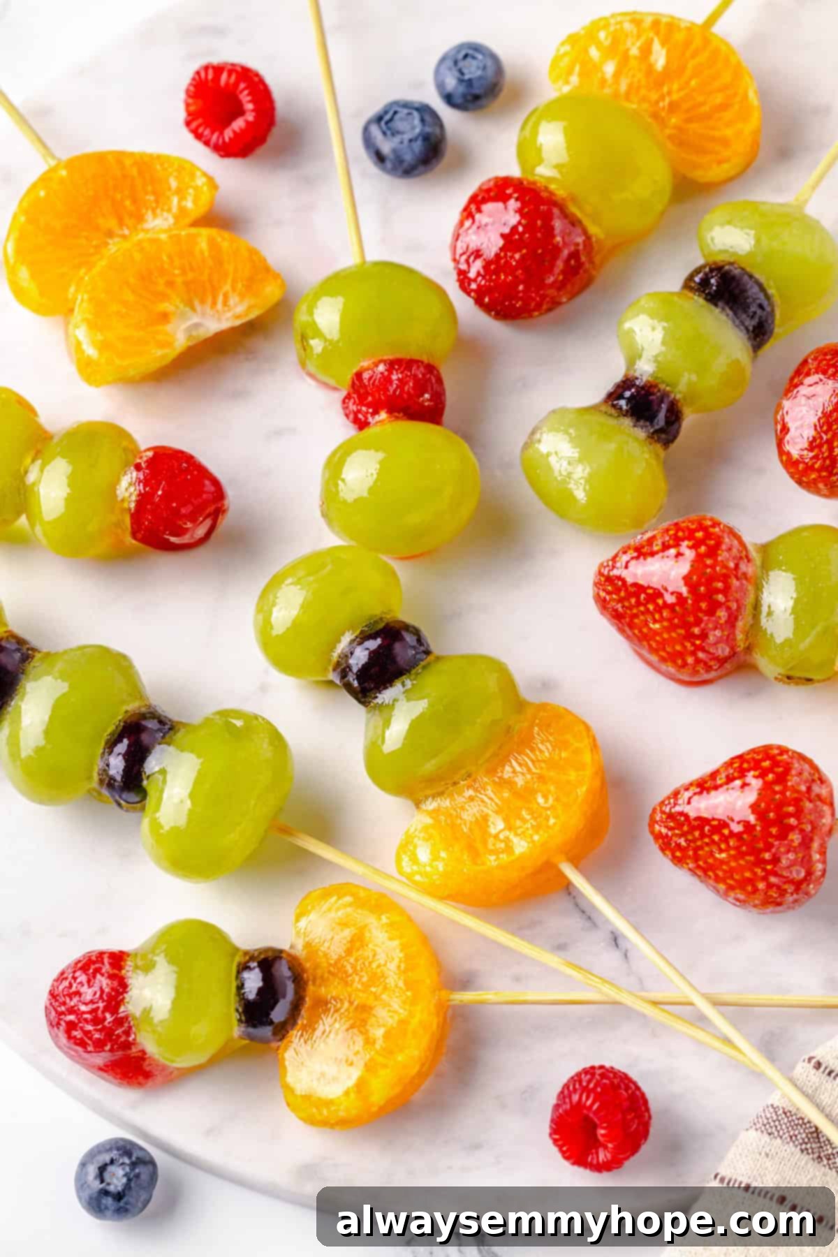 Tanghulu is one part fruit, one part candy and entirely delicious! Fruit skewers dipped in candy coating to create a sweet, crunchy shell. Marble platter with tanghulu