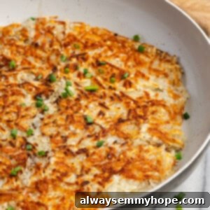 Crispy hash browns in a skillet with a wooden spoon