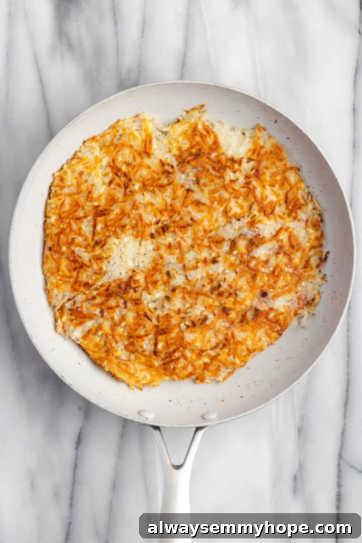 Close-up of golden-brown hash browns cooked to perfection in a skillet, ready to be served.