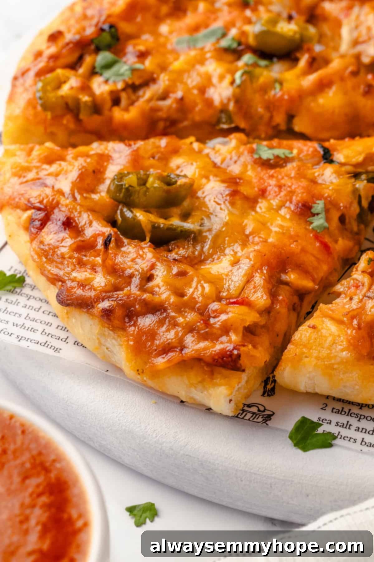 This vegan birria pizza recipe has all the savory, spicy goodness and toppings of birria tacos, but in the form of a cheesy pizza! Close-up of a freshly baked, sliced vegan birria pizza on a marble board, ready to be served