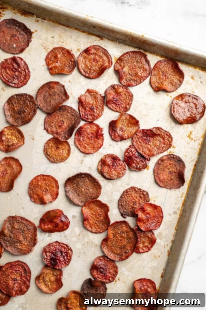 Overhead view of baked beet chips on sheet pan