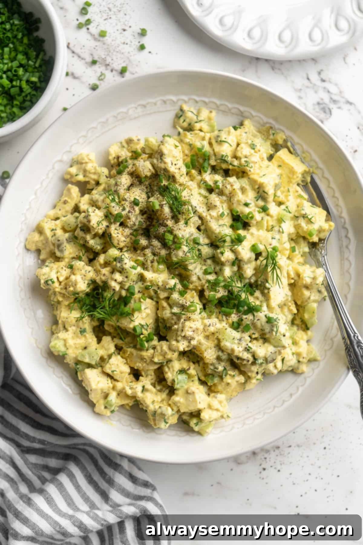 Overhead view of tofu egg salad in bowl with fork