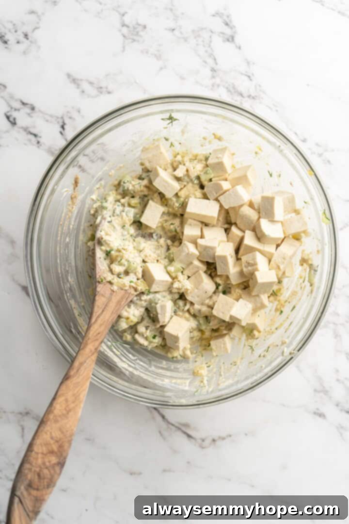 Stirring cubed tofu into tofu egg salad