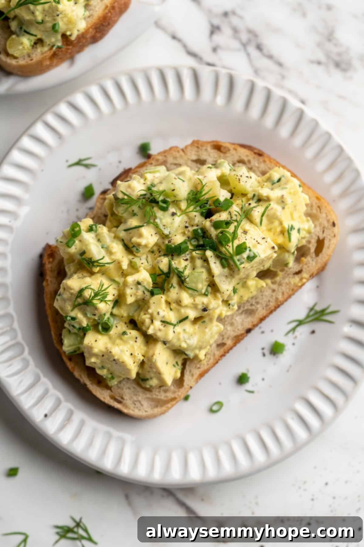 Overhead view of tofu egg salad on slice of bread