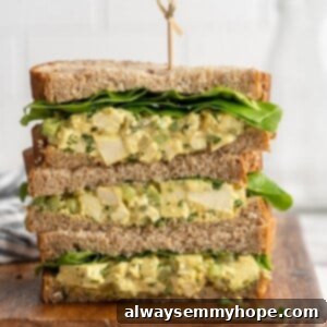 3 stacked tofu egg salad sandwiches on cutting board