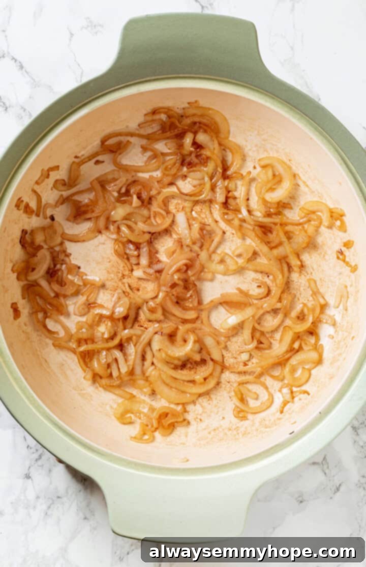 This vegan stromboli recipe is like a giant pizza roll, with marinara, plant-based cheese and veggies baked inside a golden brown crust. Yum! Overhead view of sauteed onions in pan