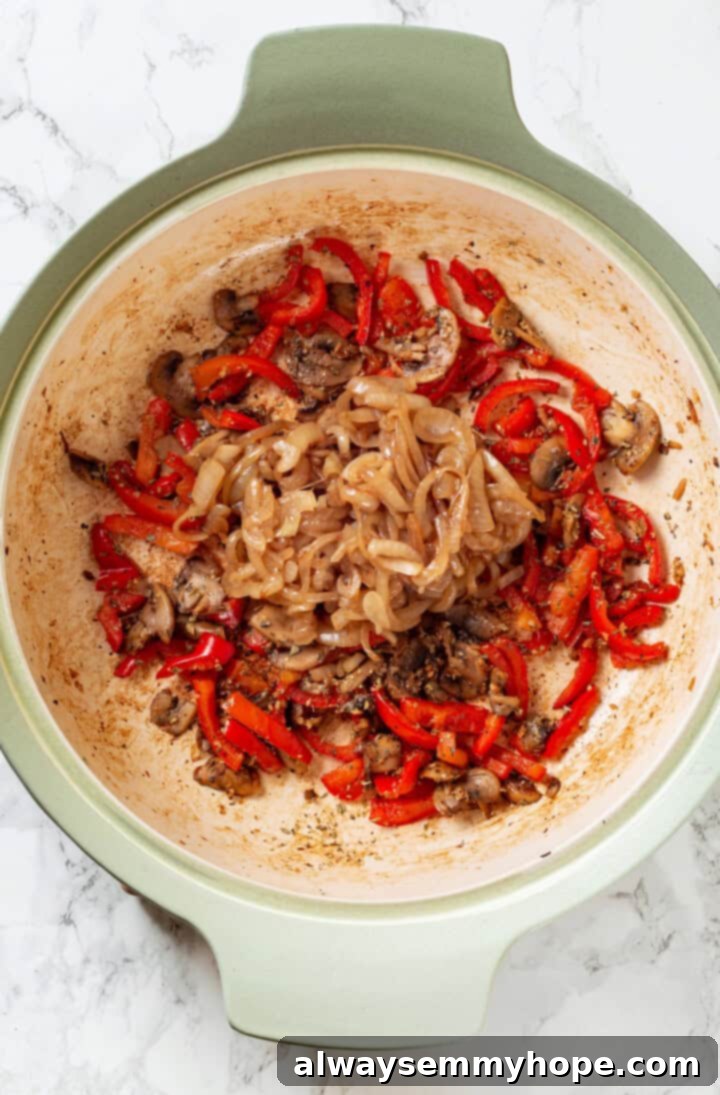 This vegan stromboli recipe is like a giant pizza roll, with marinara, plant-based cheese and veggies baked inside a golden brown crust. Yum! Overhead view of cooked vegetables for stromboli recipe