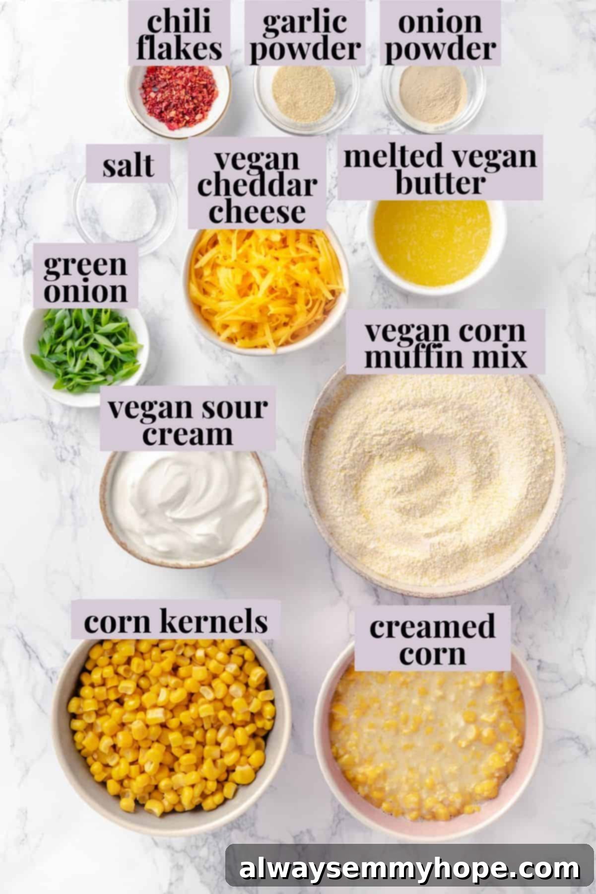 This easy vegan corn casserole is creamy, cheesy and sweet, with all the flavour you love of the holiday classic. Always a crowd-pleaser! Individual ingredients for a vegan corn casserole laid out on a clean counter: corn muffin mix, canned corn, creamed corn, vegan sour cream, vegan butter, seasonings, vegan cheddar cheese, and green onions.