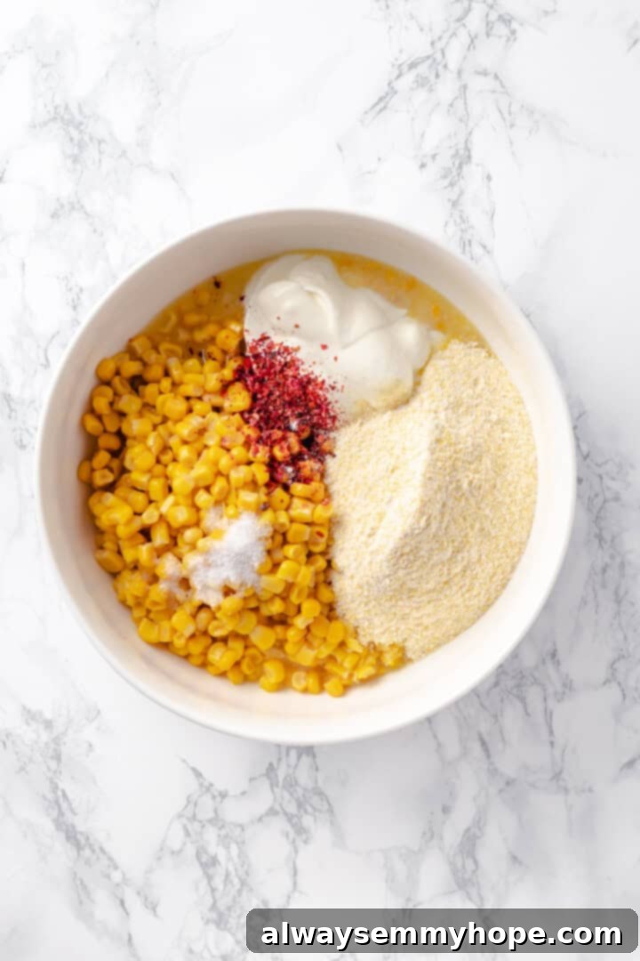 This easy vegan corn casserole is creamy, cheesy and sweet, with all the flavour you love of the holiday classic. Always a crowd-pleaser! Overhead view of all wet and dry ingredients for vegan corn casserole mixed together in a large mixing bowl, ready for baking.