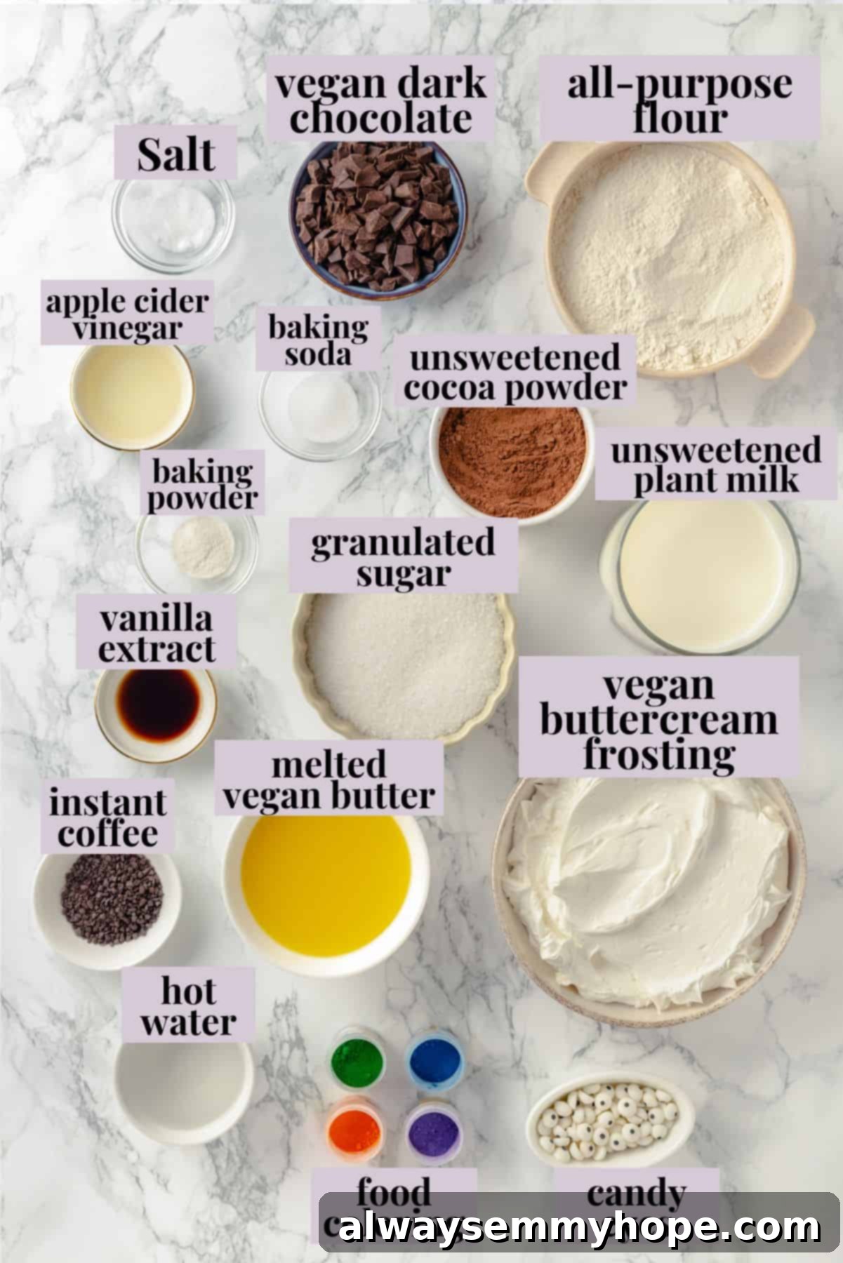 These moist chocolate Halloween cupcakes are topped with cute frosting monsters in a variety of colours. They taste as good as they look and are perfect for vegan celebrations! Overhead flat lay of all ingredients for vegan Halloween chocolate monster cupcakes, clearly labeled for easy preparation, including flour, sugar, cocoa, plant milk, vegan butter, and candy eyes.