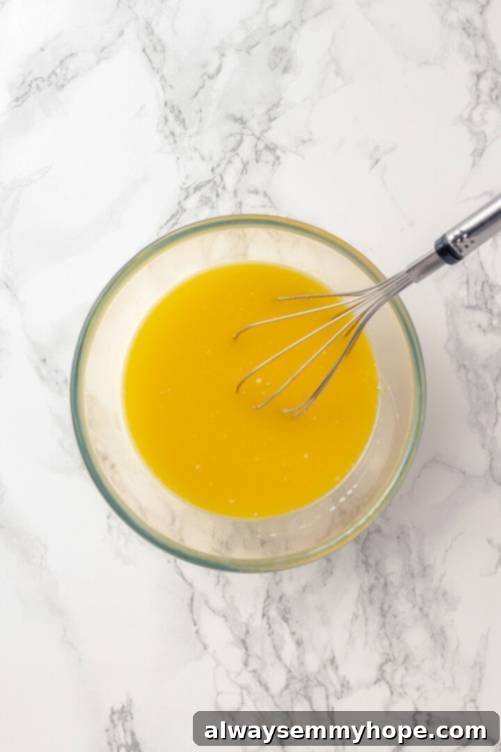 These moist chocolate Halloween cupcakes are topped with cute frosting monsters in a variety of colours. They taste as good as they look! Liquid mixture for vegan chocolate cupcakes in a glass bowl, featuring plant-based milk, melted vegan butter, apple cider vinegar, and vanilla extract, ready to be combined with dry ingredients.