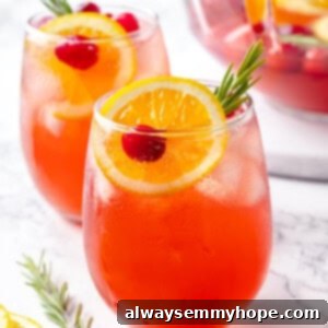 Two glasses of Christmas punch with bowl in background