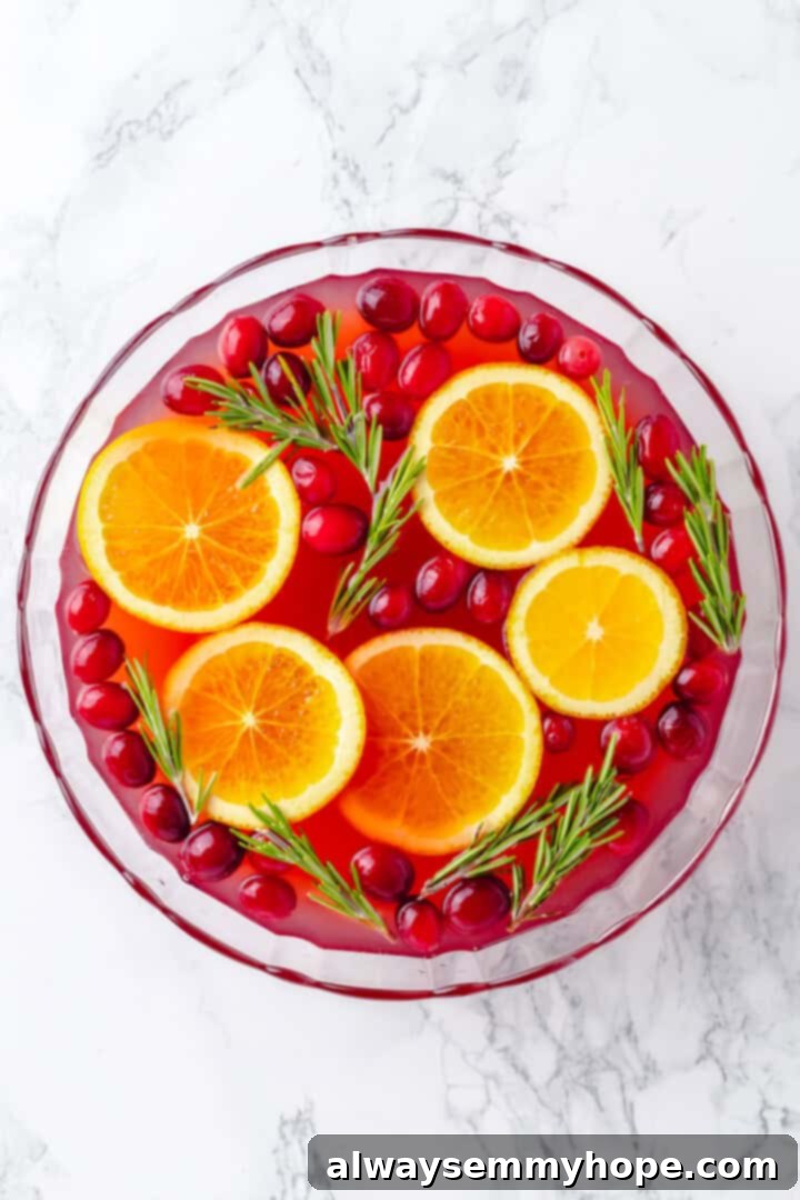 Overhead view of a Christmas punch in a serving bowl, now with rum added and ready for garnishing.