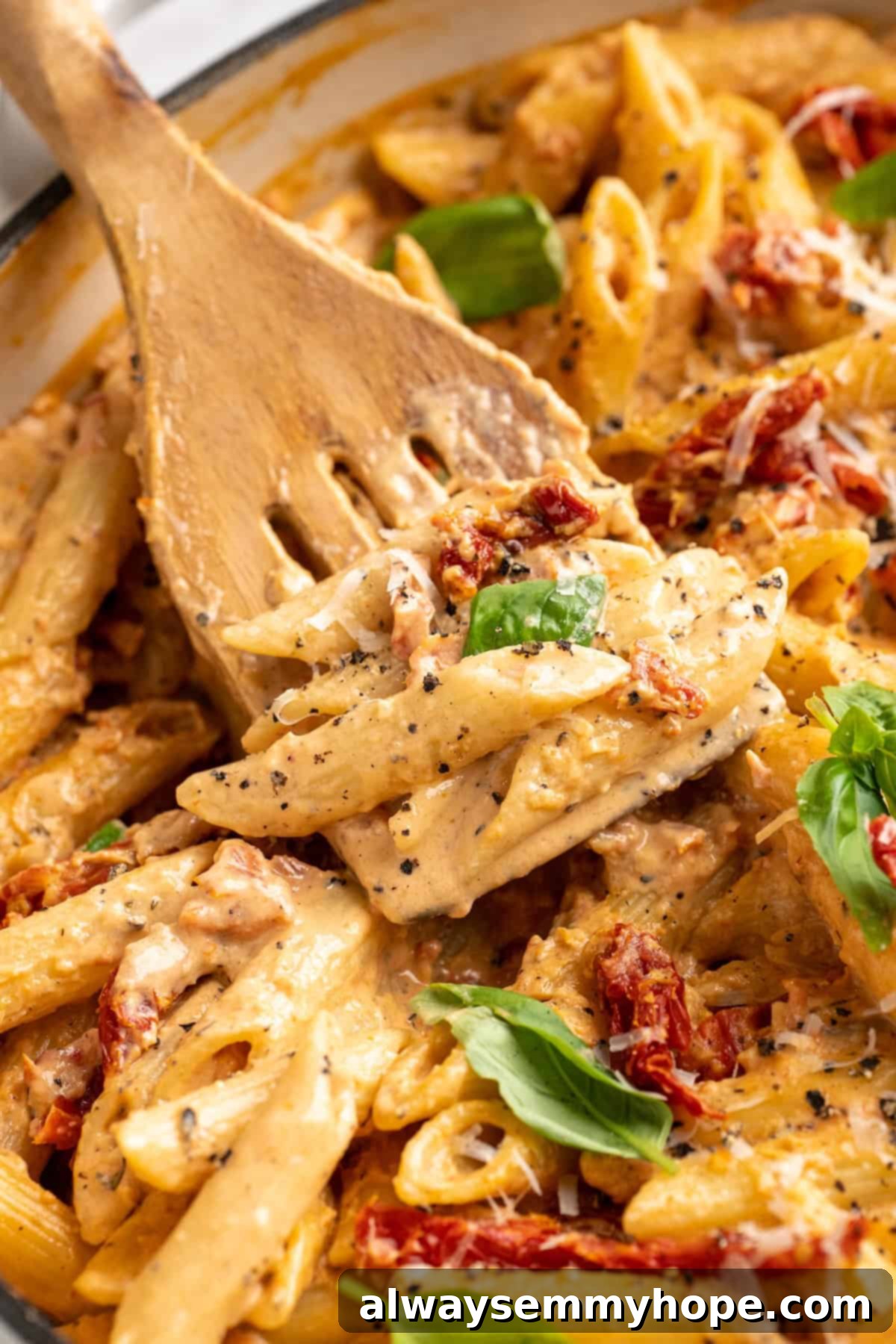 Slotted spoon stirring vegan marry me pasta in pan