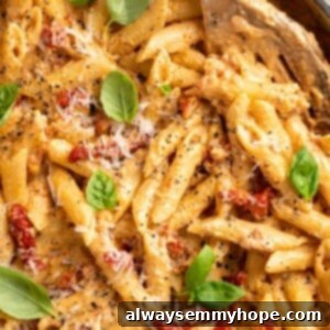 Overhead view of vegan marry me pasta in skillet with slotted spoon