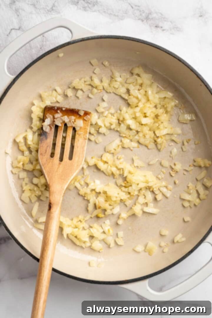 Overhead view of diced onions cooking in skillet