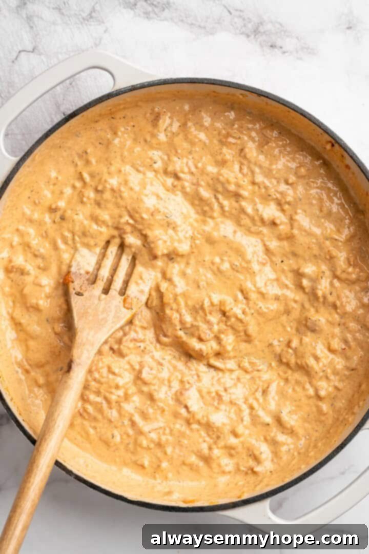 Overhead view of vegan marry me sauce in skillet with slotted spoon