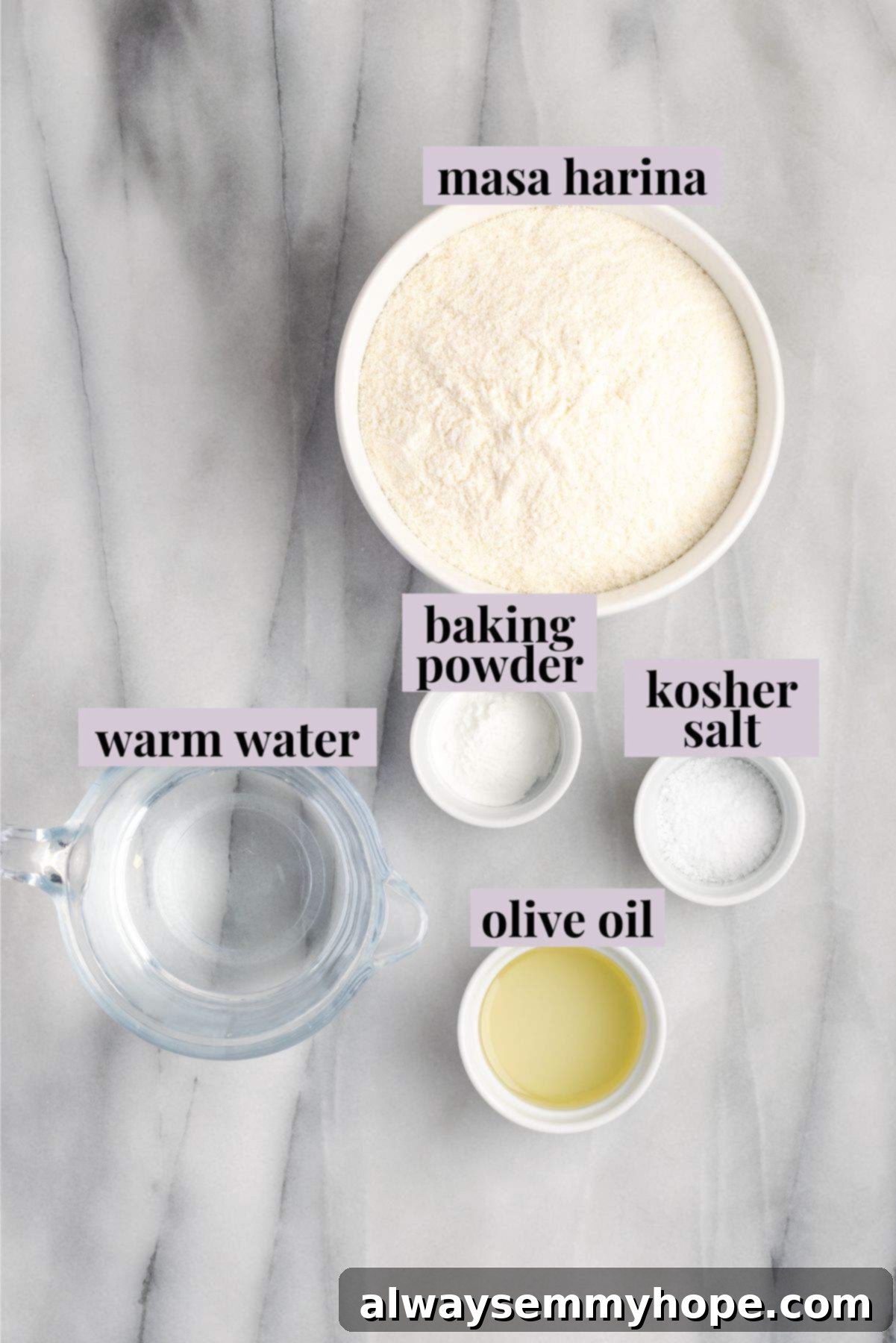 Overhead view of the ingredients for homemade gordita dough, including a bowl of masa harina, olive oil, salt, baking powder, and a glass of warm water, arranged on a rustic wooden surface.