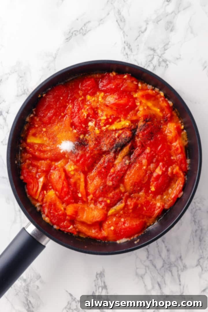 This homemade pomodoro sauce recipe takes a short list of simple ingredients and transforms them into a fresh, vibrant pasta sauce. So easy! Overhead view of sugar being added to a simmering pan of pomodoro sauce, along with tomatoes and other seasonings.