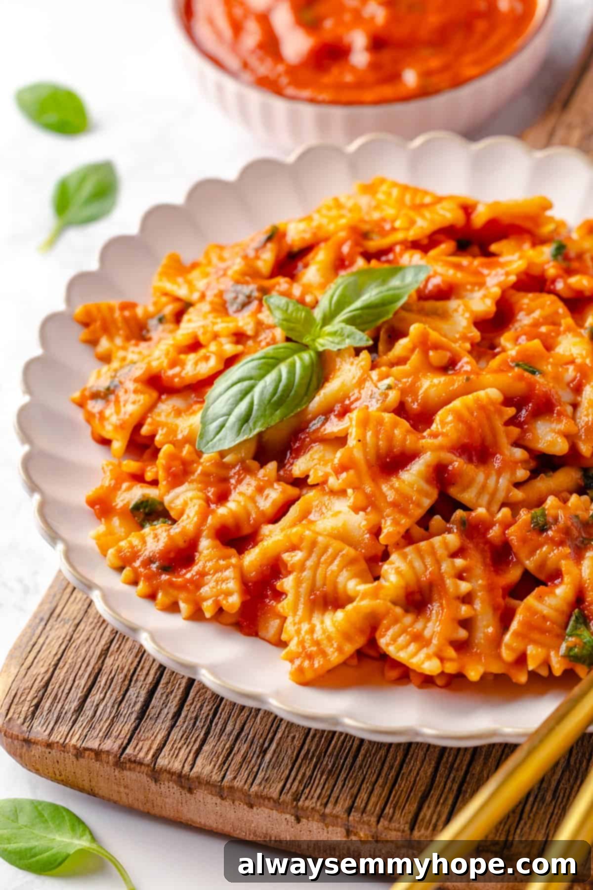 This homemade pomodoro sauce recipe takes a short list of simple ingredients and transforms them into a fresh, vibrant pasta sauce. So easy! Plate of spaghetti tossed with vibrant red pomodoro sauce and garnished with fresh basil leaves.