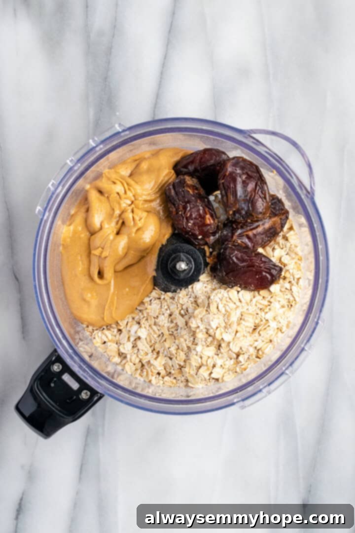 These homemade vegan protein bars are an easy, no-bake recipe that you can customise with your favourite flavours and mix-ins. So tasty! Rolled oats, nut butter, and pitted Medjool dates being processed in a food processor for protein bars