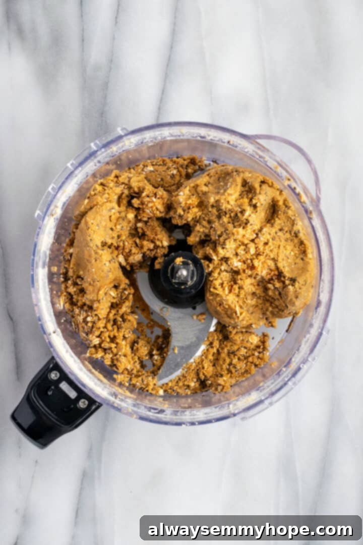 These homemade vegan protein bars are an easy, no-bake recipe that you can customise with your favourite flavours and mix-ins. So tasty! Protein bar mixture, after all ingredients are combined, in a food processor