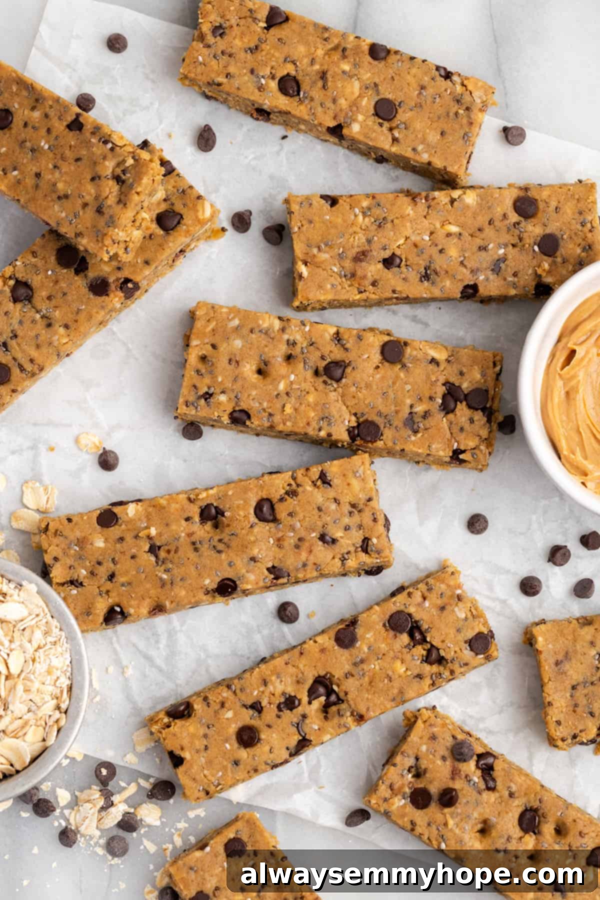 These homemade vegan protein bars are an easy, no-bake recipe that you can customise with your favourite flavours and mix-ins. So tasty! Overhead view of sliced chocolate chip protein bars on parchment paper