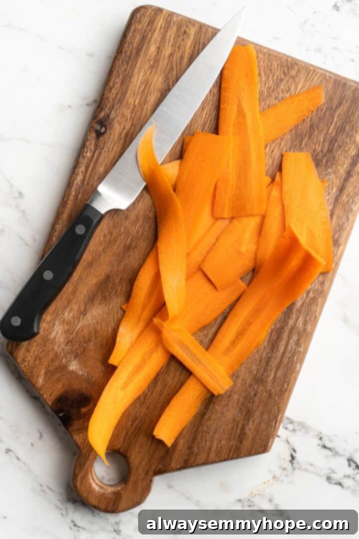 Thinly sliced carrots meticulously prepared on a cutting board, alongside a sharp knife for precision.