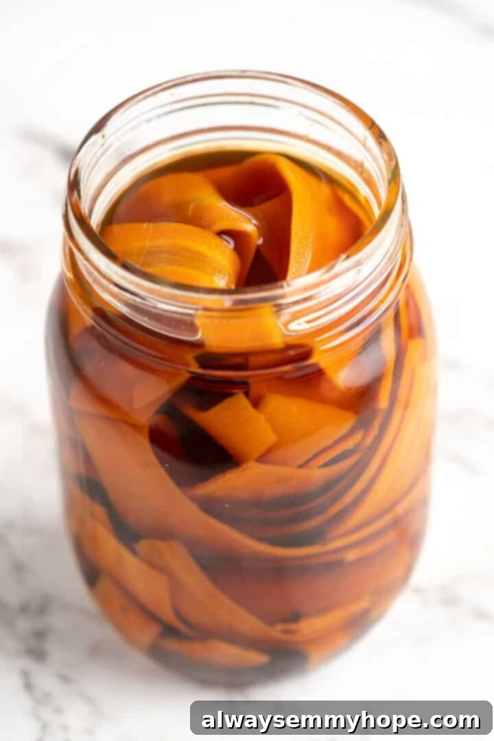 Carrot lox fully submerged in its flavorful brine, actively pickling in a sealed glass jar.