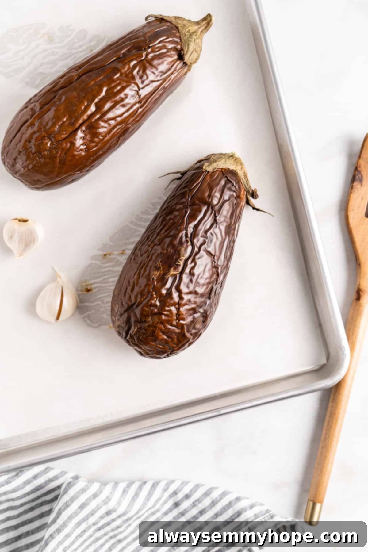 Roasted eggplants and garlic on baking sheet after baking