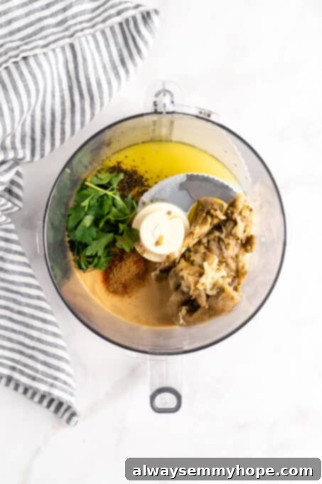 Overhead view of baba ghanoush ingredients being added to a food processor