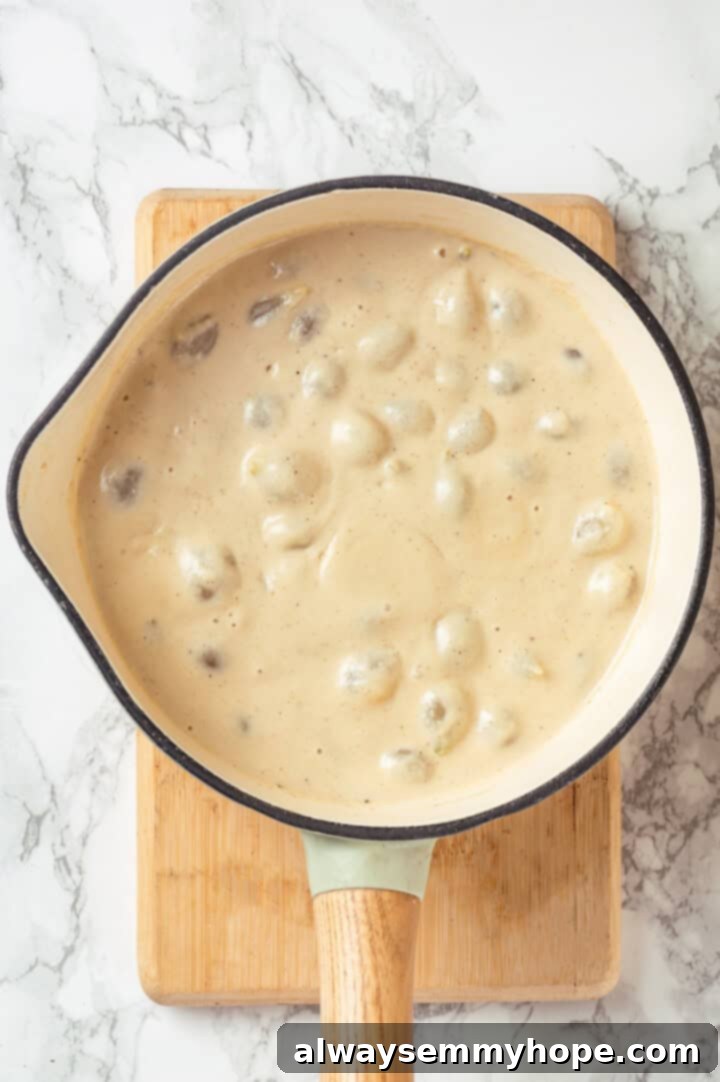 These creamed onions are sweet, savoury, and rich. A stovetop recipe perfect for holiday dinners but easy enough for a weeknight! Overhead view of creamed onions in pan