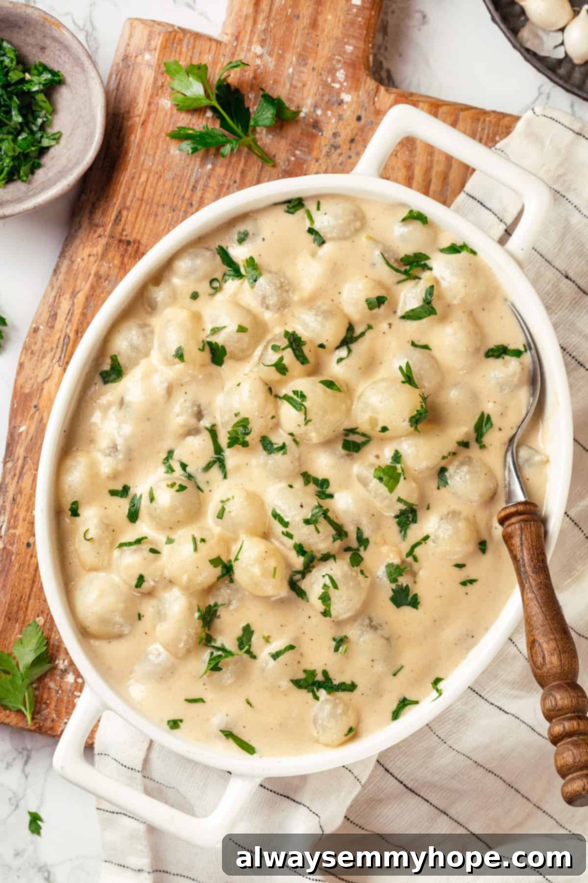 These creamed onions are sweet, savoury, and rich. A stovetop recipe perfect for holiday dinners but easy enough for a weeknight! Overhead view of vegan creamed onions in serving dish