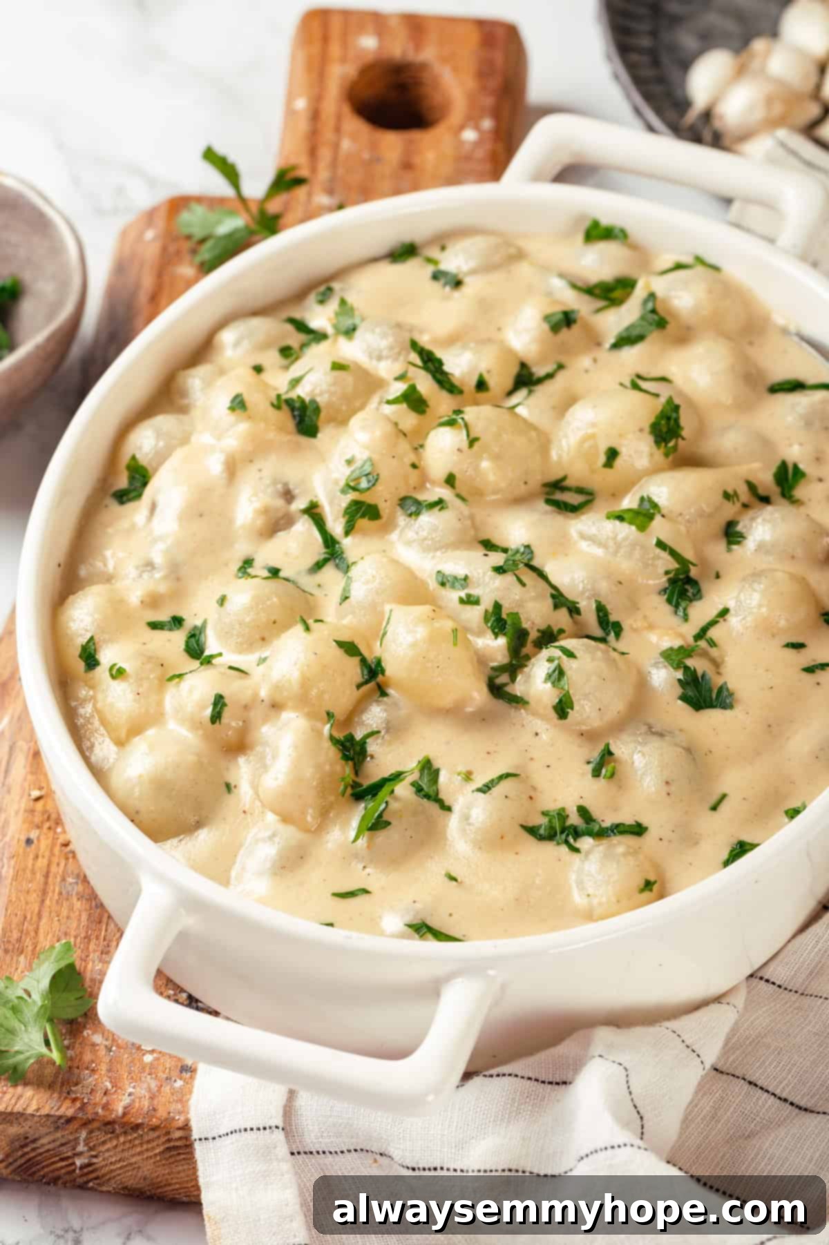 These creamed onions are sweet, savoury, and rich. A stovetop recipe perfect for holiday dinners but easy enough for a weeknight! Vegan creamed onions in serving dish