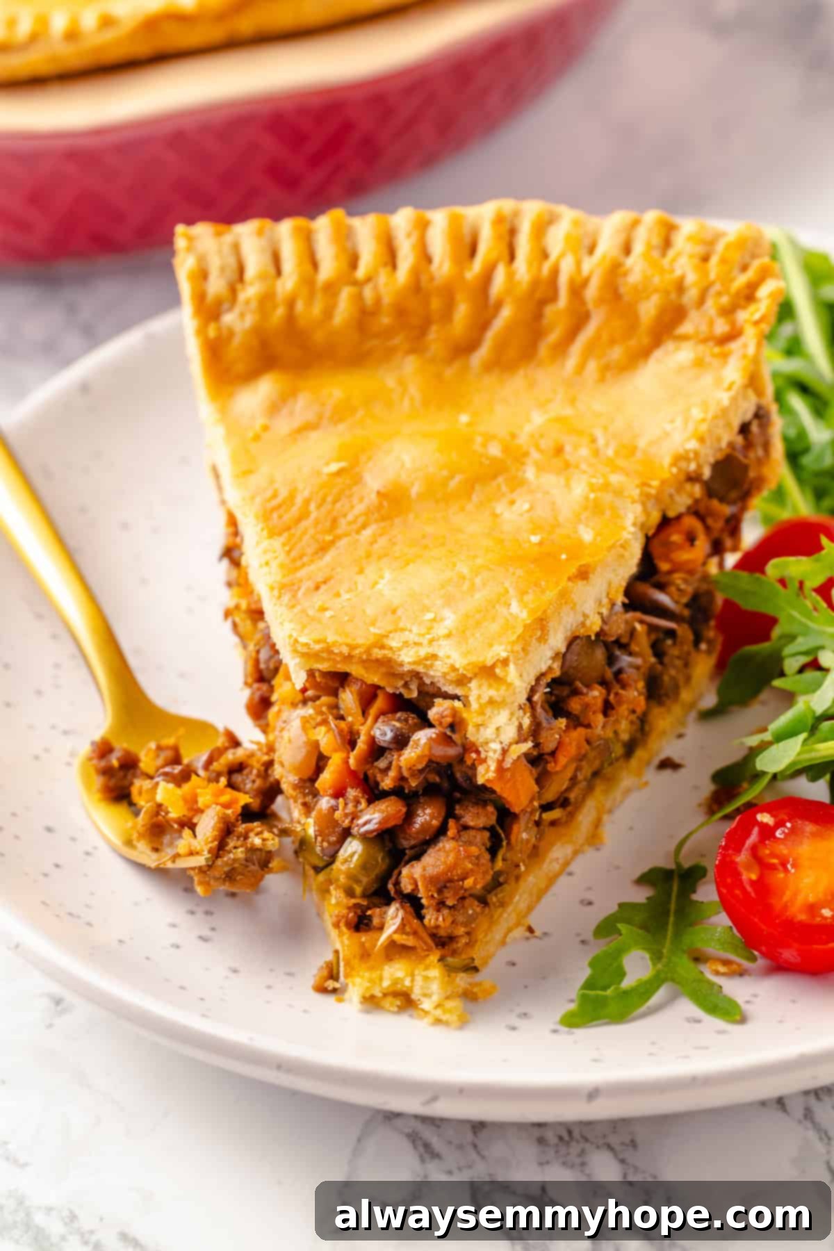 Tourtière slice on plate with salad, ready to be enjoyed