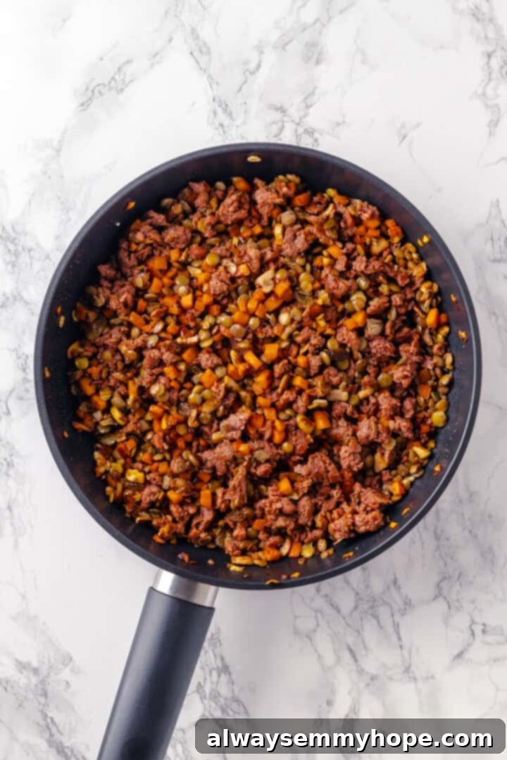 Filling for tourtière in skillet after stirring in herbs, spices, lentils, and vegan ground meat