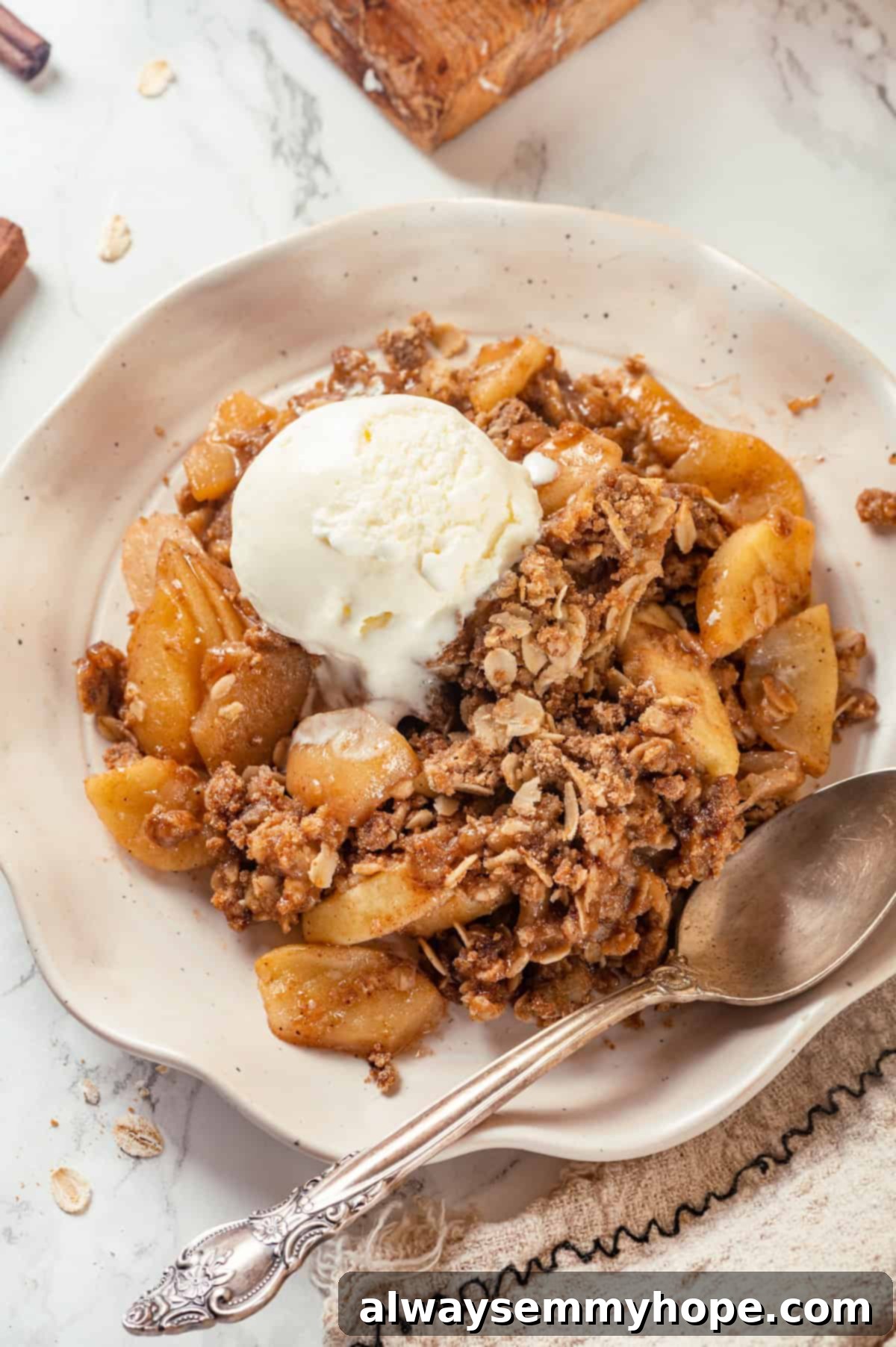 Overhead view of apple crisp in bowl with scoop of vanilla ice cream