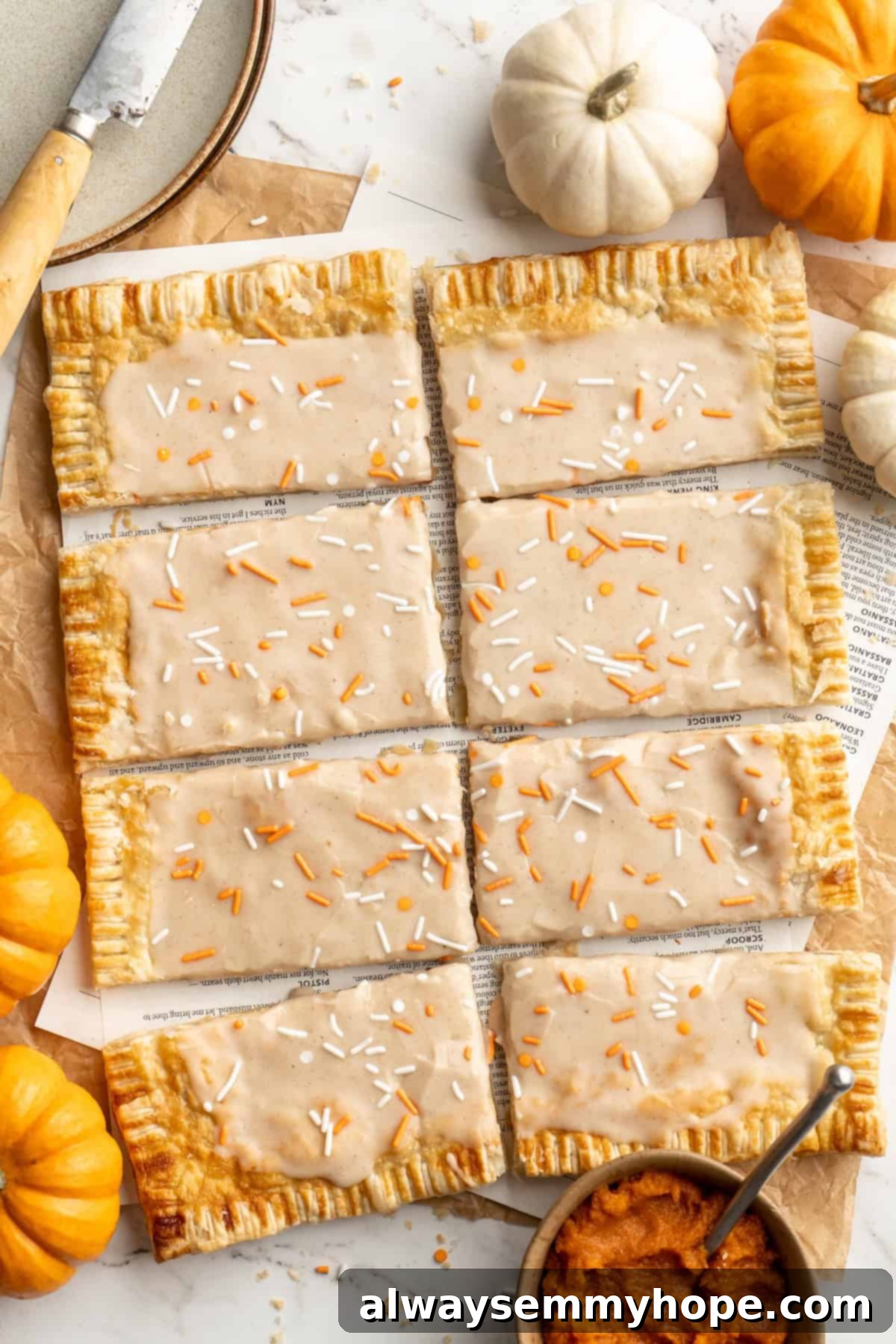 A cozy pumpkin-spiced filling is tucked into flaky vegan puff pastry to make these easy and delicious homemade pumpkin pop tarts! Overhead view of homemade vegan pumpkin pop tarts, cut into squares and ready to be served.