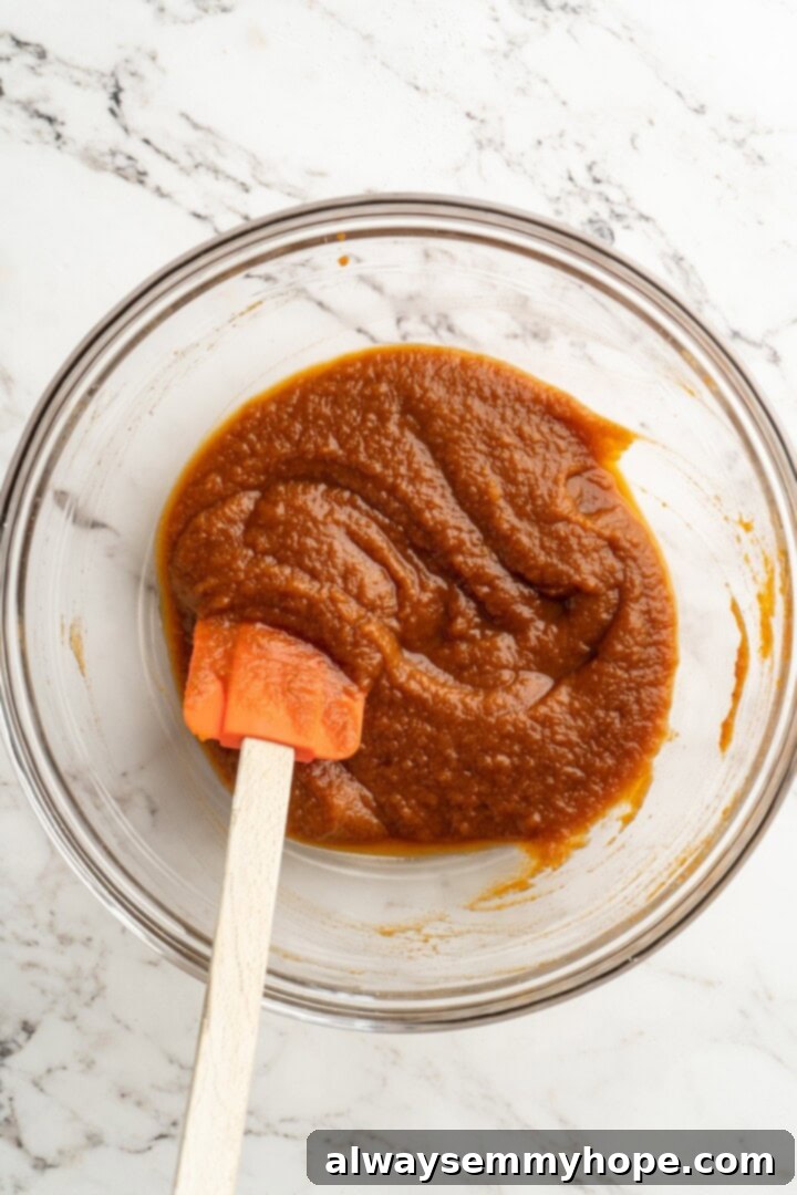 A cozy pumpkin-spiced filling is tucked into flaky vegan puff pastry to make these easy and delicious homemade pumpkin pop tarts! Pumpkin filling in a mixing bowl with a rubber spatula, ready to be spread.