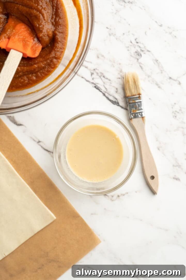 A cozy pumpkin-spiced filling is tucked into flaky vegan puff pastry to make these easy and delicious homemade pumpkin pop tarts! Vegan egg wash mixture in a small bowl with a pastry brush.